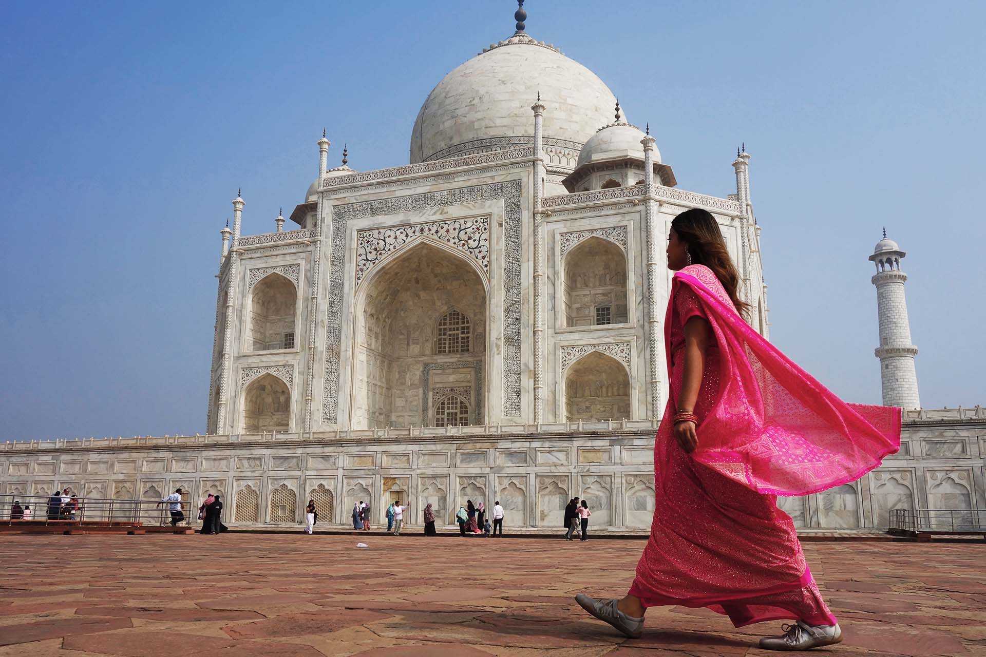 民族衣装サリーを着てタージマハールを歩く女性