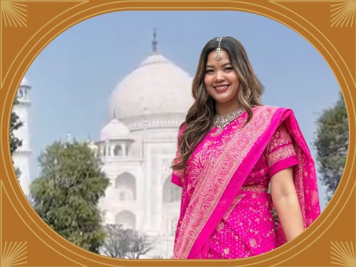 タージ・マハルでピンクのサリーを着て記念撮影する女性